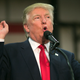 Trump pretending to smoke a long skinny cigarette to seem cool. Image via Getty.